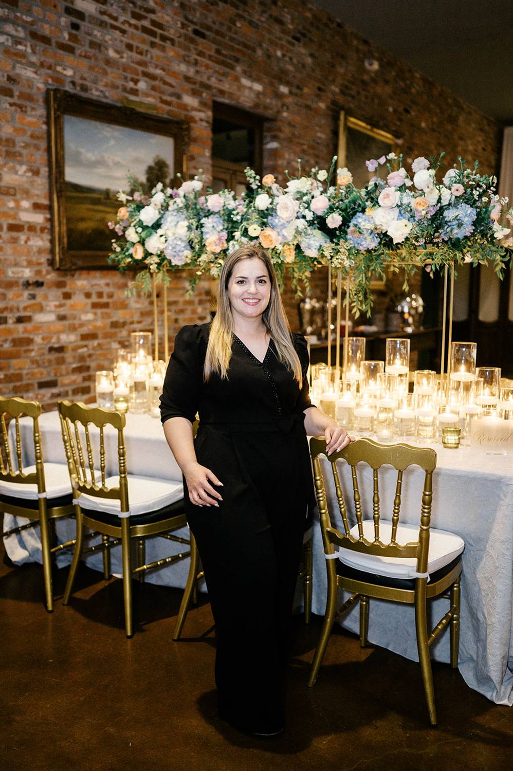 Nancy stands beside a finished floral arch she designed