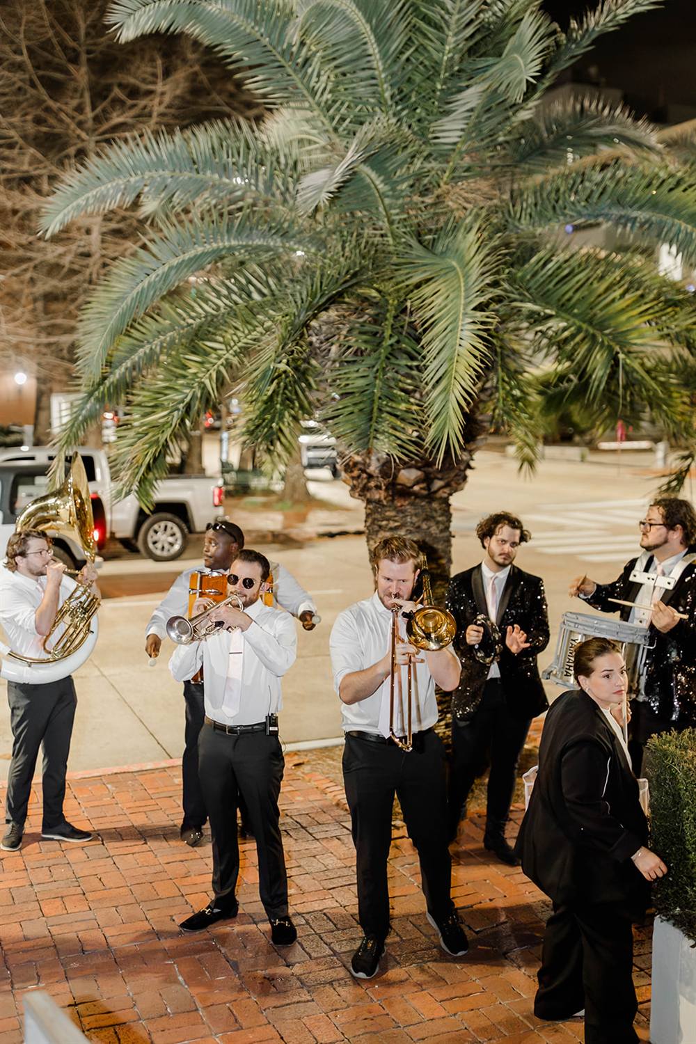 A brass second-line band leads the celebration through the crowd
