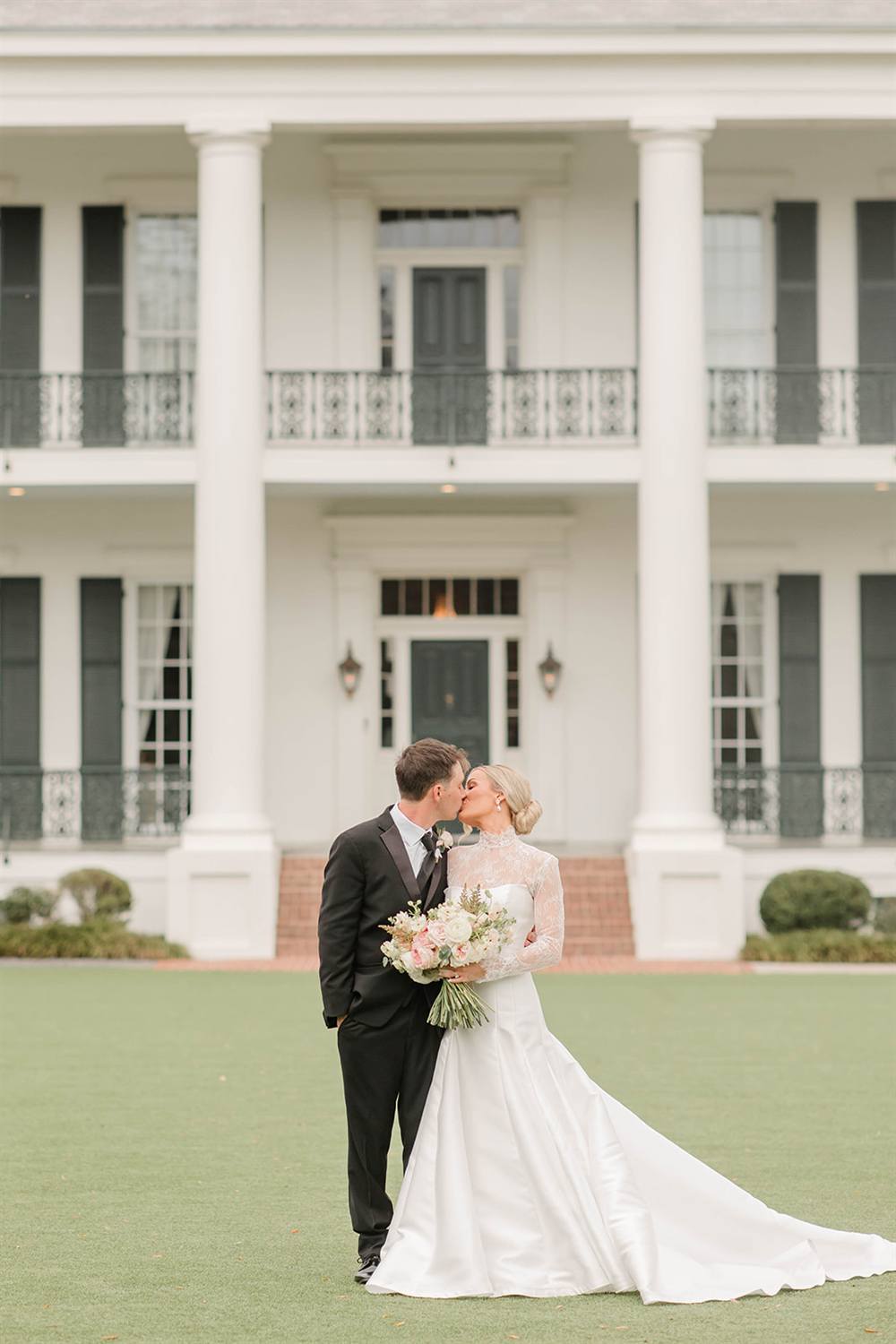 A kiss on the steps of a white columned mansion