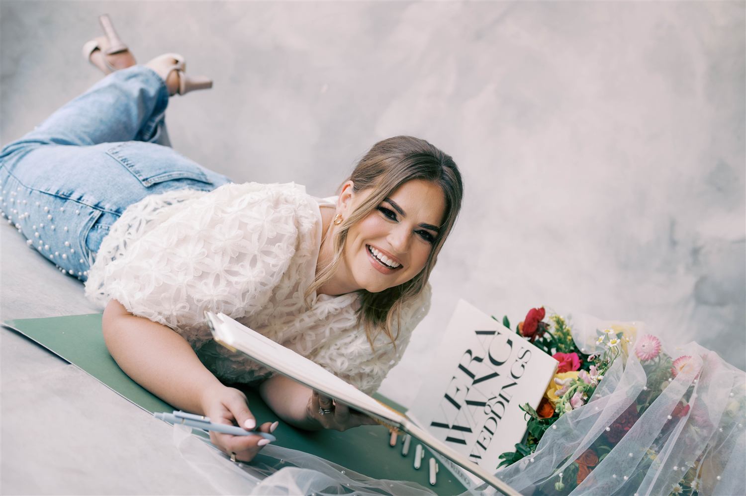 Nancy laughs beside a bouquet and a hand-lettered wedding sign