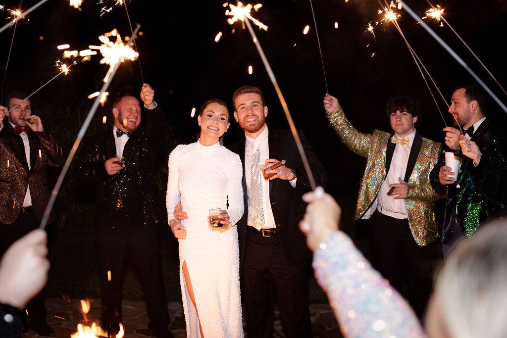 Guests celebrate poolside with sparklers at night
